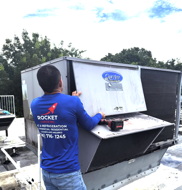 Rocket HVACR technician servicing a commercial rooftop HVAC unit